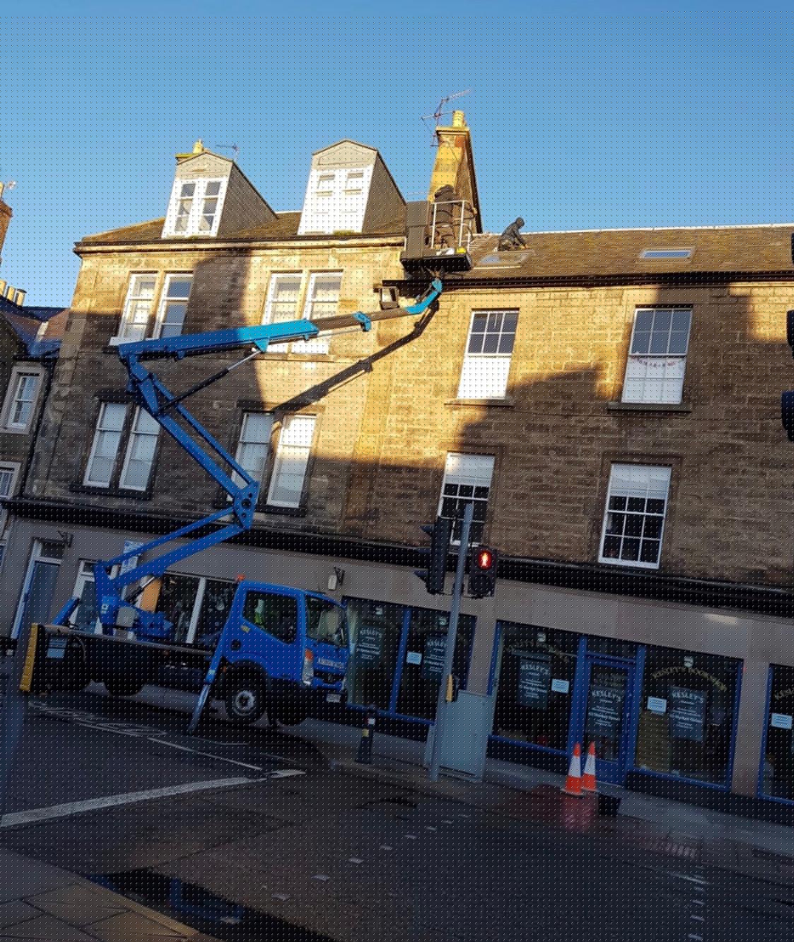 Roofing team working on a local stone building